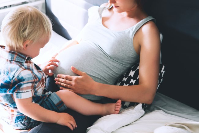 Small Boy touching his moms tummy